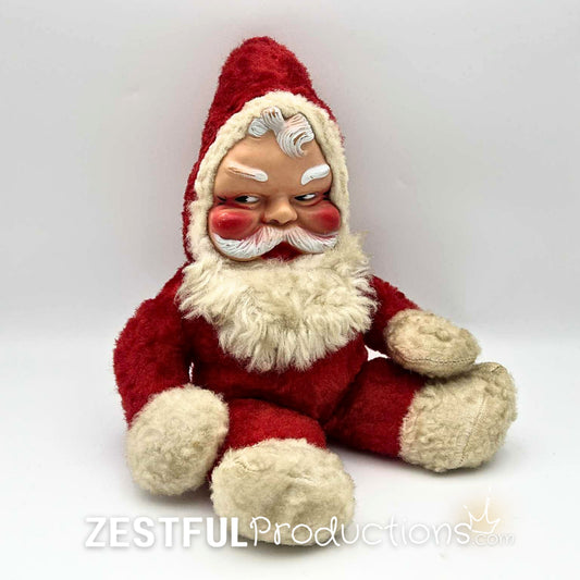 Vintage 1950s Rushton style Santa Claus plush doll collectible sitting upright with molded face, red suit, fluffy white beard, and mid century Christmas charm for retro holiday decor and antique toy collectors.