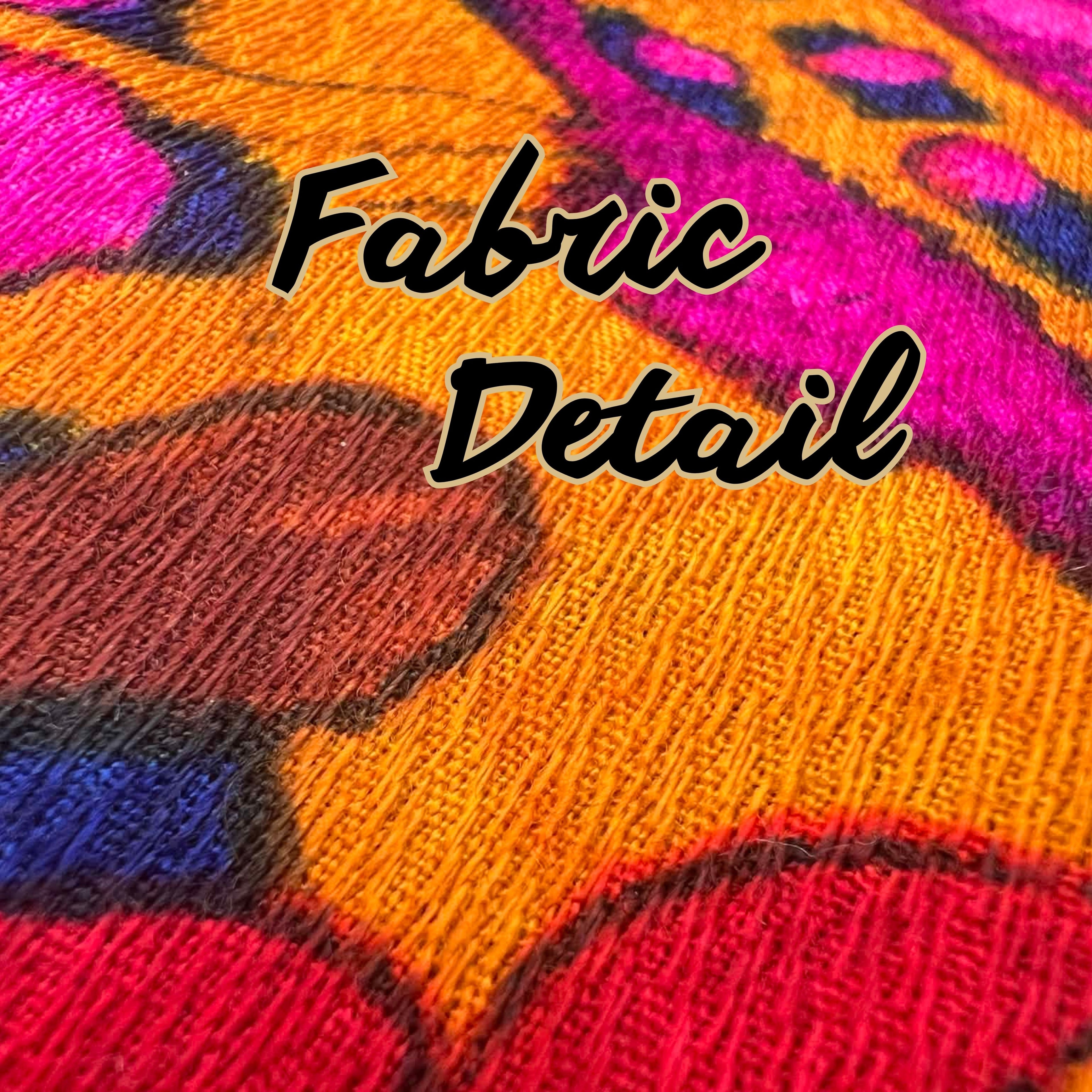Detailed view of vintage curtain fabric texture in bold pink, orange, and yellow tones.