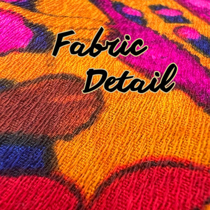 Detailed view of vintage curtain fabric texture in bold pink, orange, and yellow tones.