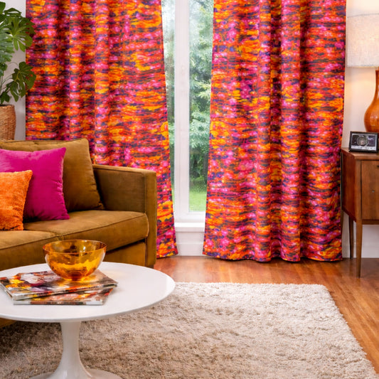 Vintage 1970s psychedelic curtain panels in bold pink, orange, and yellow abstract pattern shown in a mock up living room setting.