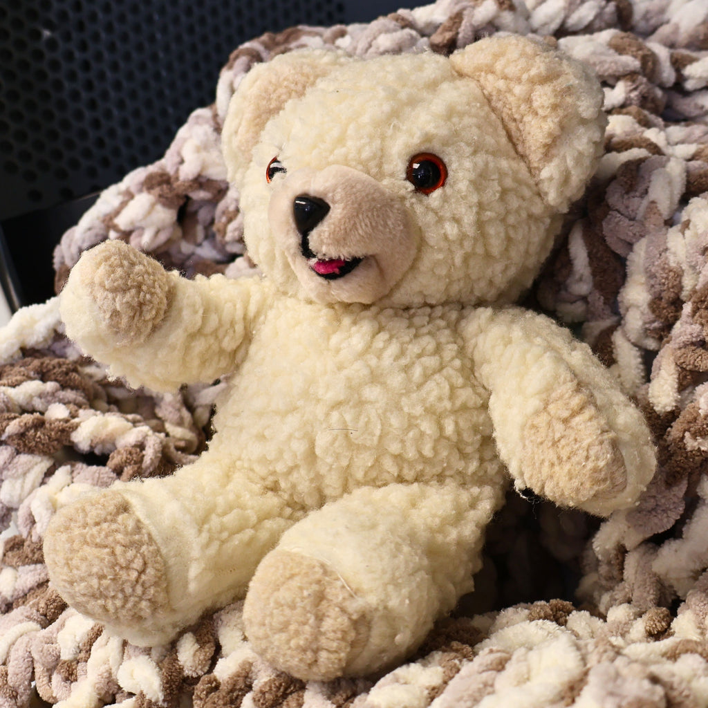 Authentic 1986 Lever Brothers Snuggle Bear plush photographed from an angled front view, highlighting its fluffy cream fur, raised arms, cheerful expression, and classic advertising mascot design. Perfect for vintage toy collectors, nostalgic displays, and cozy home decor.
