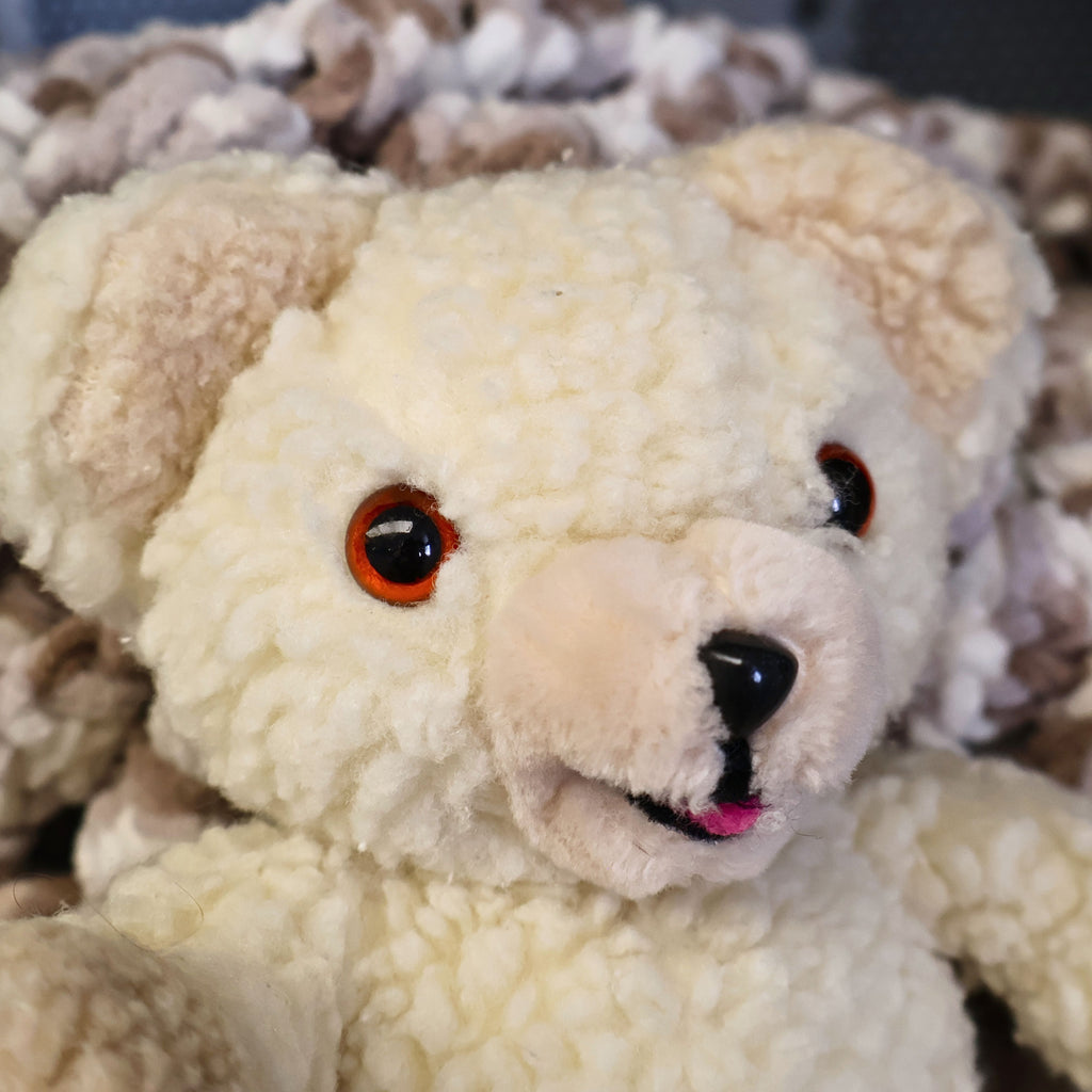 Vintage 1986 Snuggle Bear plush by Lever Brothers and Russ Berrie & Co. close-up showing its smiling face, cream sherpa plush, amber eyes, and original vintage character details. A nostalgic advertising collectible ideal for laundry room decor, vintage plush collections, and retro home decorating.