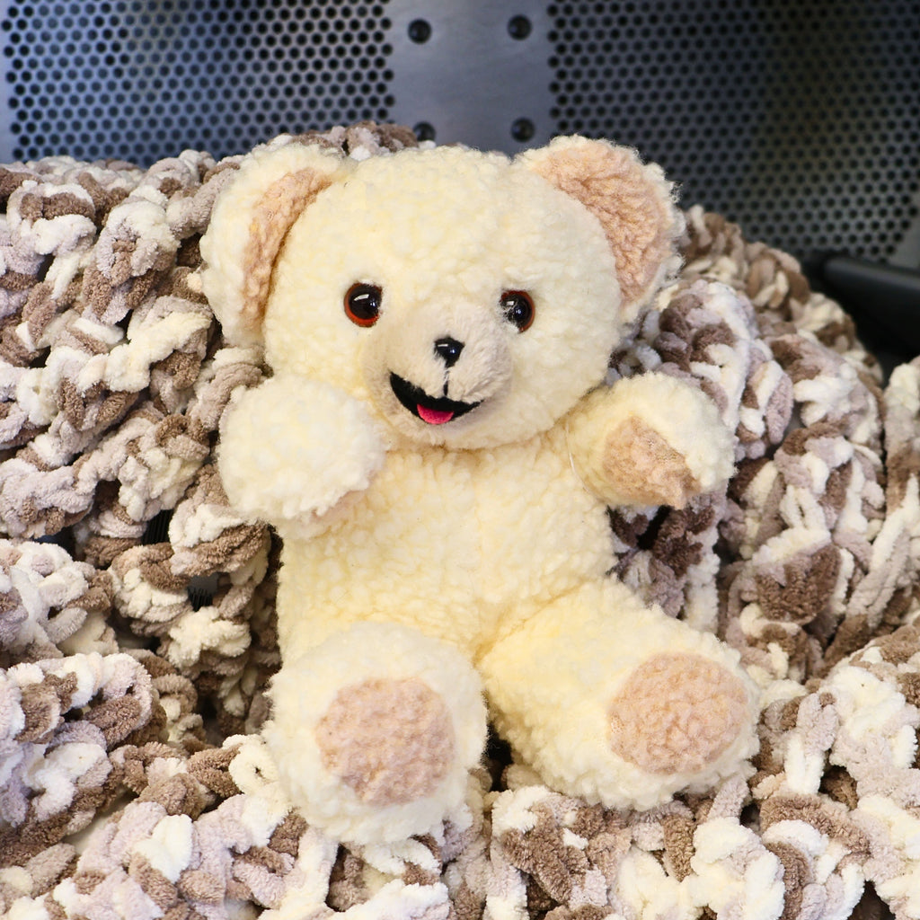 Vintage 1997 Snuggle Bear plush by Lever Brothers Company sitting upright with a smiling face and soft ivory sherpa fur. This original 10-inch fabric softener mascot makes a charming vintage advertising collectible, laundry room accent, nostalgic gift, or retro plush display.
