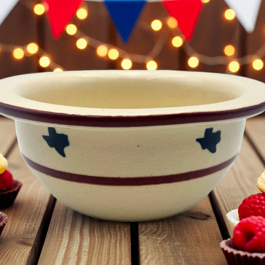 Decorative bowl with Texas star design on a wooden table with festive lights in the background