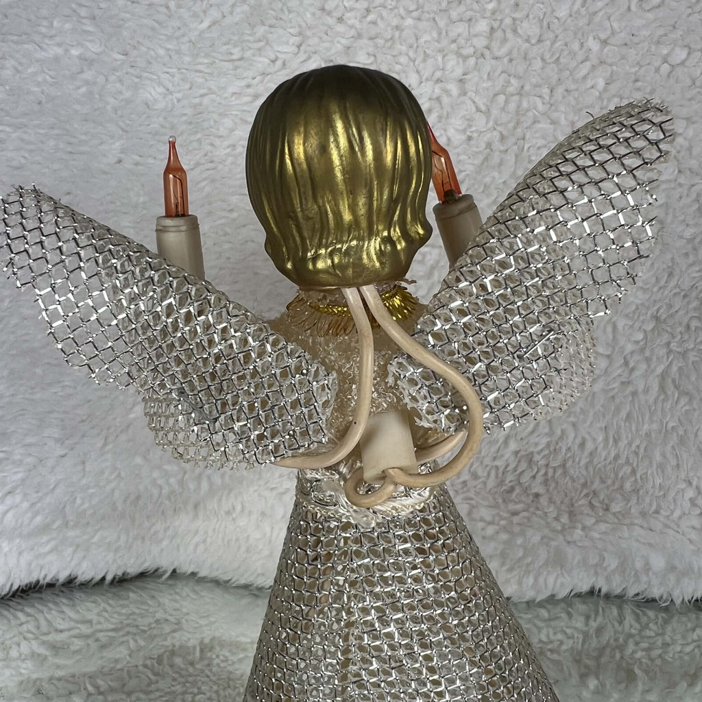 Close-up of the back of a vintage angel tree topper, showing molded gold-colored hair above a cream textured bodice. Silver mesh wings extend to either side, ivory-colored wiring runs behind the figure, and the upper portion of the mesh skirt fills the lower view.