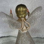 Close-up of the back of a vintage angel tree topper, showing molded gold-colored hair above a cream textured bodice. Silver mesh wings extend to either side, ivory-colored wiring runs behind the figure, and the upper portion of the mesh skirt fills the lower view.