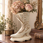 Vintage Atlantic Mold Victorian boot planter styled as a vase with muted pink roses, dried hydrangeas and greenery on an antique wood dresser. This digitally styled lifestyle scene illustrates the planter’s scale and romantic decorating potential; flowers are not included.