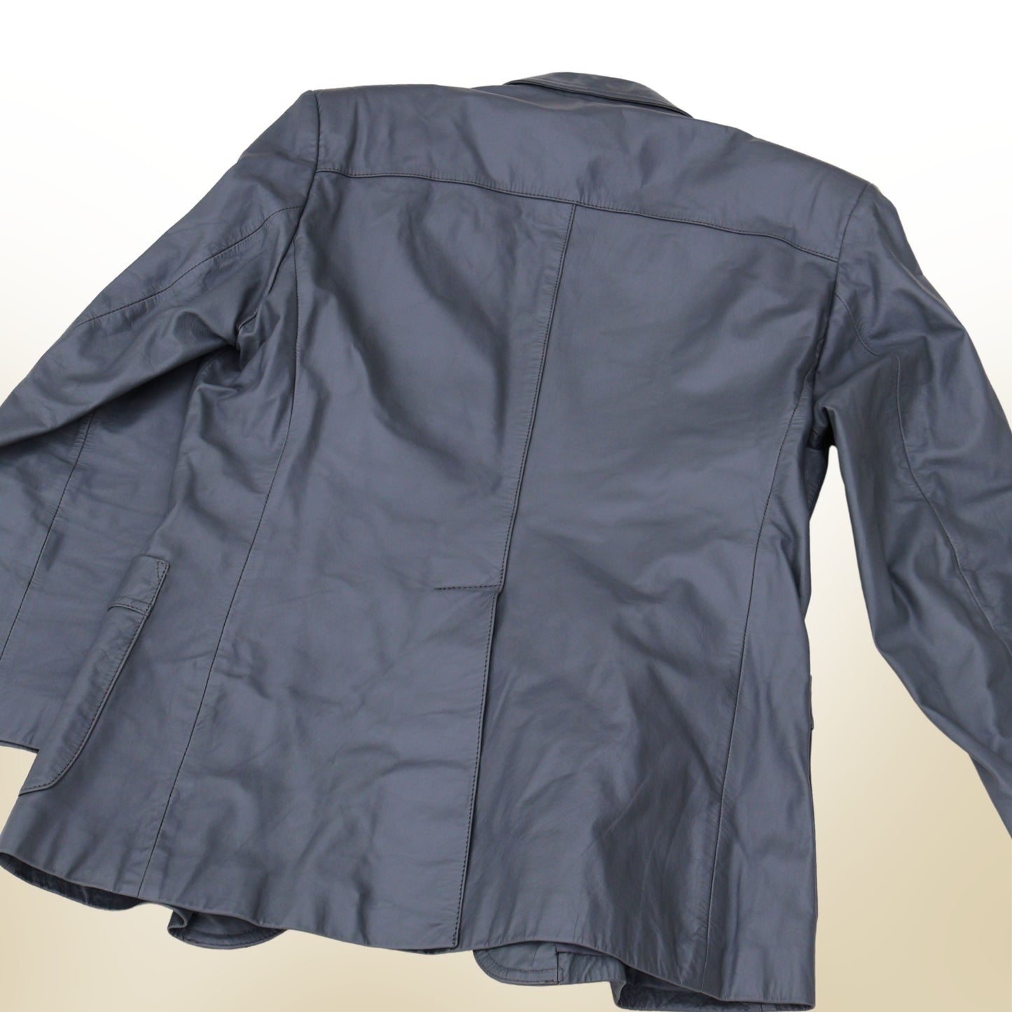 Back view of vintage gray leather blazer with structured seams and classic tailored silhouette.