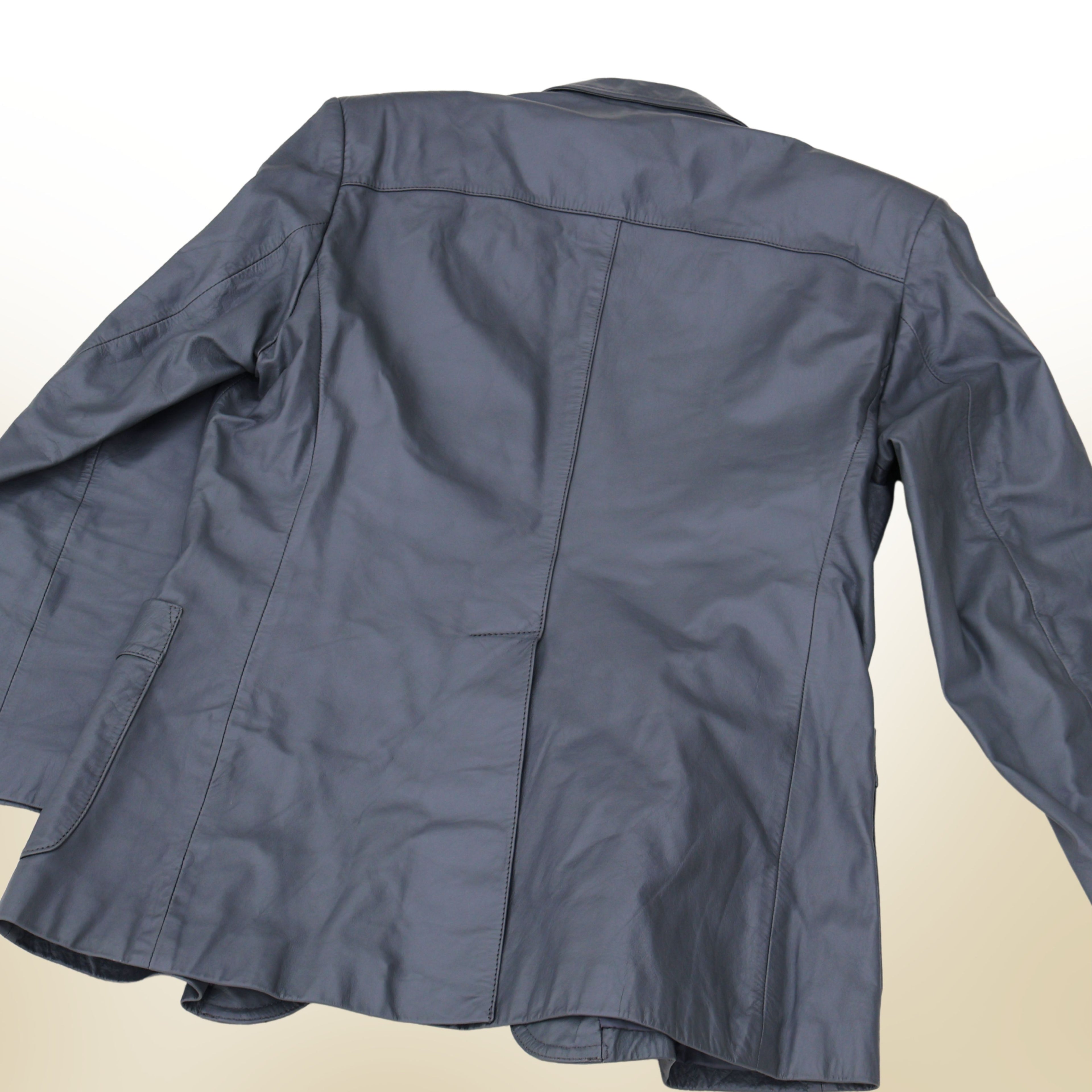 Back view of vintage gray leather blazer with structured seams and classic tailored silhouette.