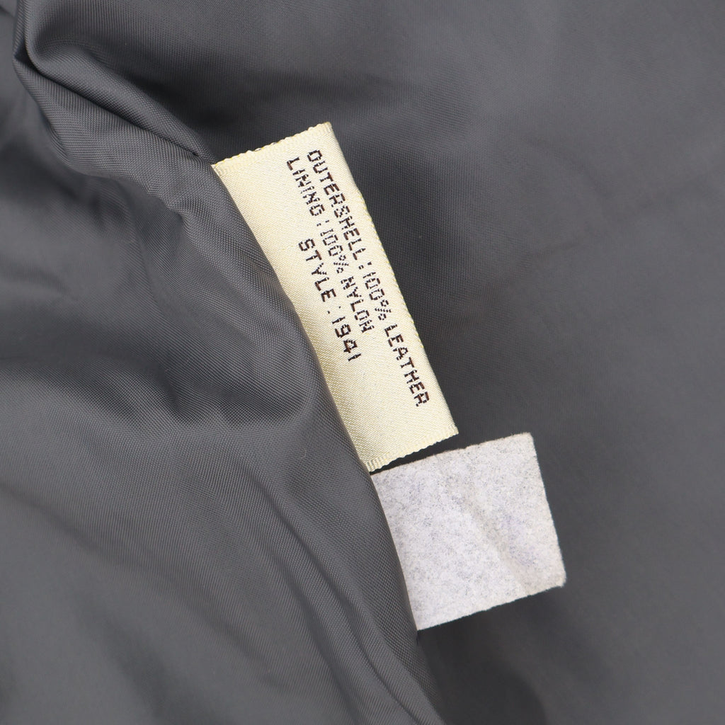 Material tag inside vintage gray leather blazer showing 100 percent leather outer shell.