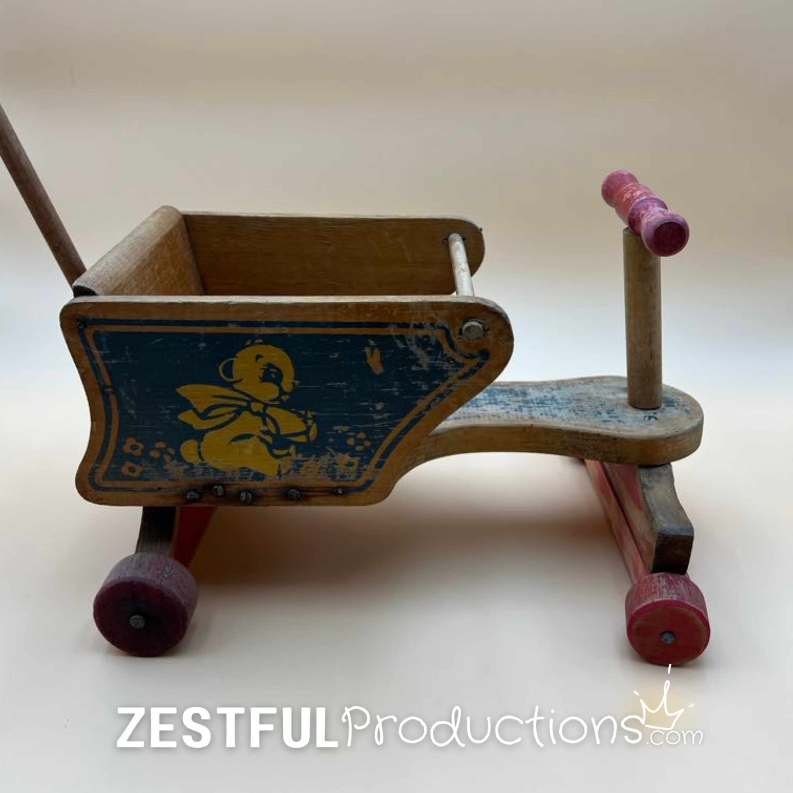 Opposite side of the vintage wooden doll stroller displaying the original blue bear artwork, natural wood finish, red painted wheels, and classic mid-century American toy design.
