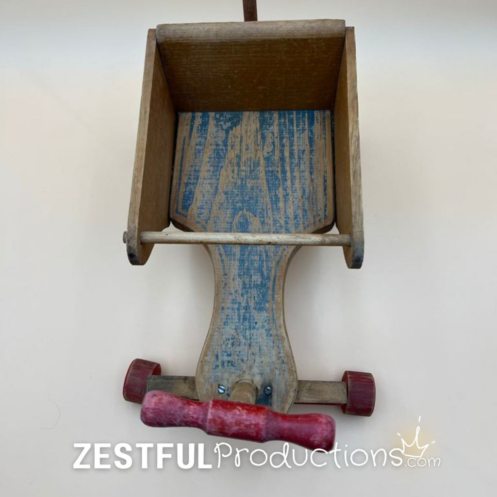 Top-front view looking into the wooden storage compartment of the 1950s Cass Toys doll push cart, highlighting the original painted floor, removable front steering handle, and sturdy handcrafted construction.