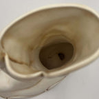 View inside the open shaft of a vintage Atlantic Mold ceramic boot planter. The photograph documents the cream-colored interior, age-related discoloration, surface marks and recessed opening near the bottom, helping shoppers assess its construction and previous use.