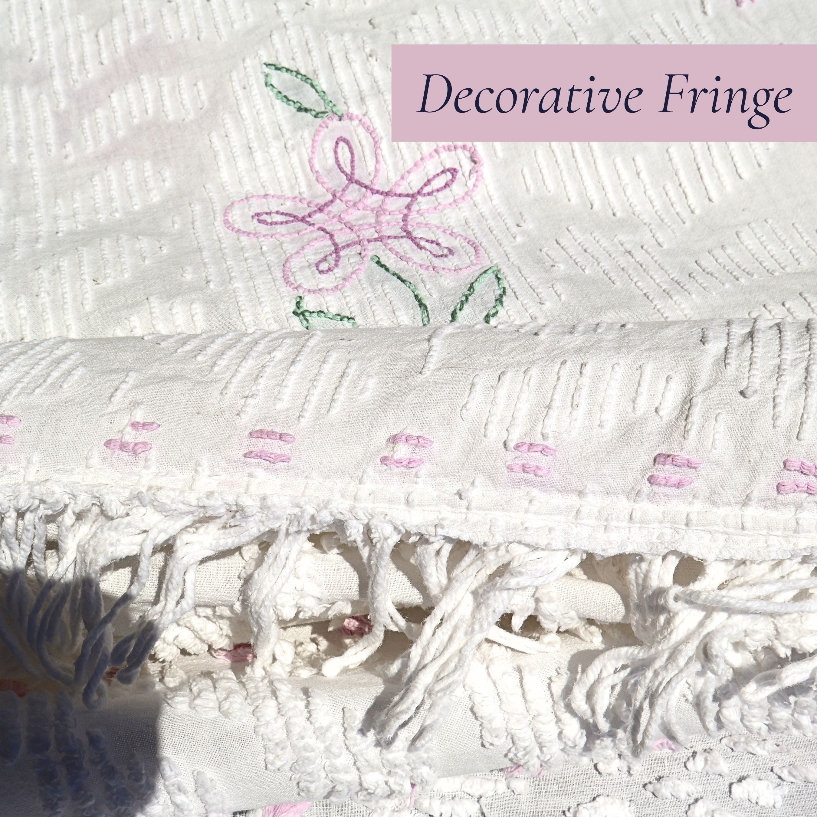 Detailed view of the original decorative fringe on a vintage white chenille bedspread. The handcrafted edge finish adds texture and authentic vintage charm, making this heirloom textile a beautiful addition to cottage decor, farmhouse bedrooms, and shabby chic interiors.