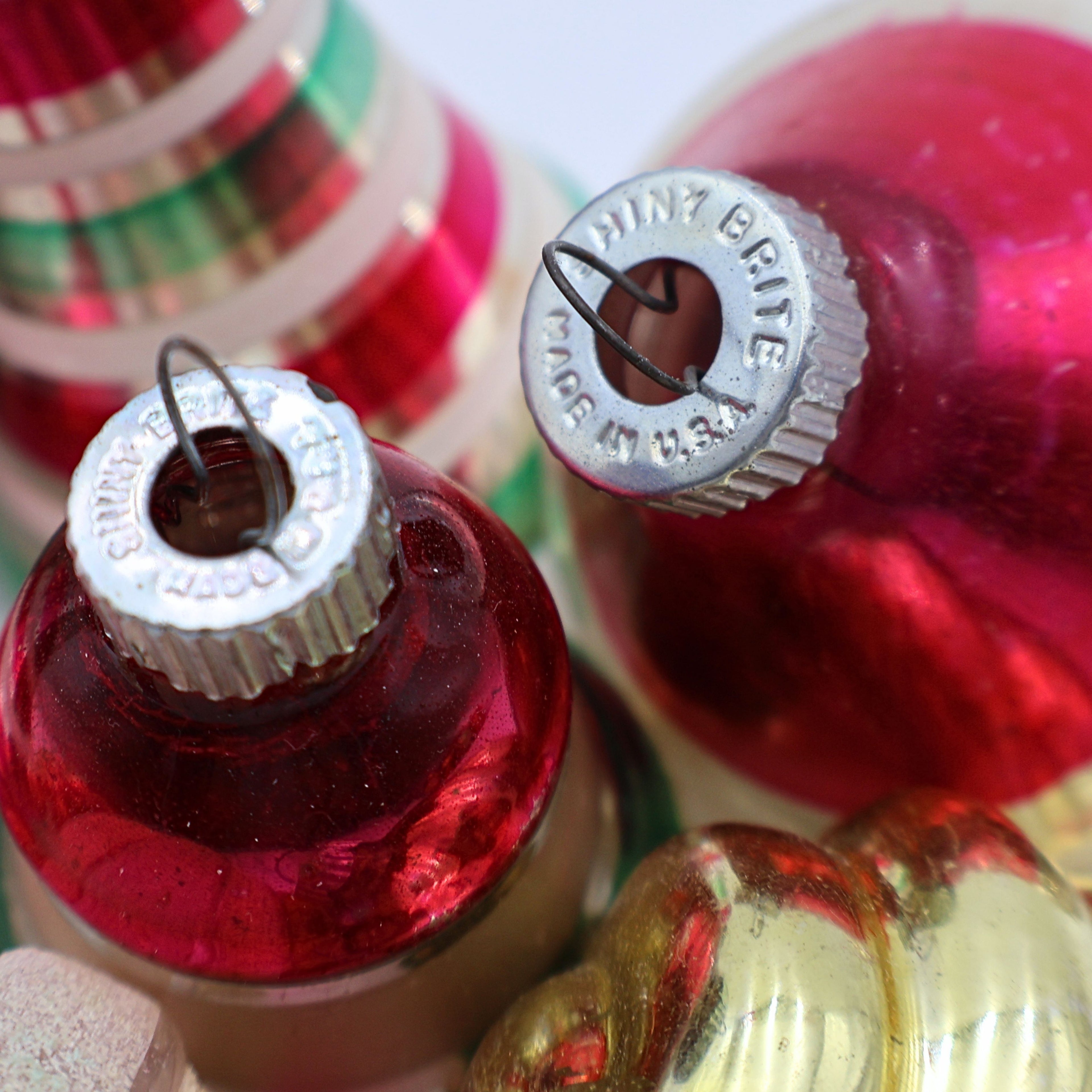 Closeup of vintage glass Christmas ornament tops showing reflective mercury glass finishes and authentic aged details