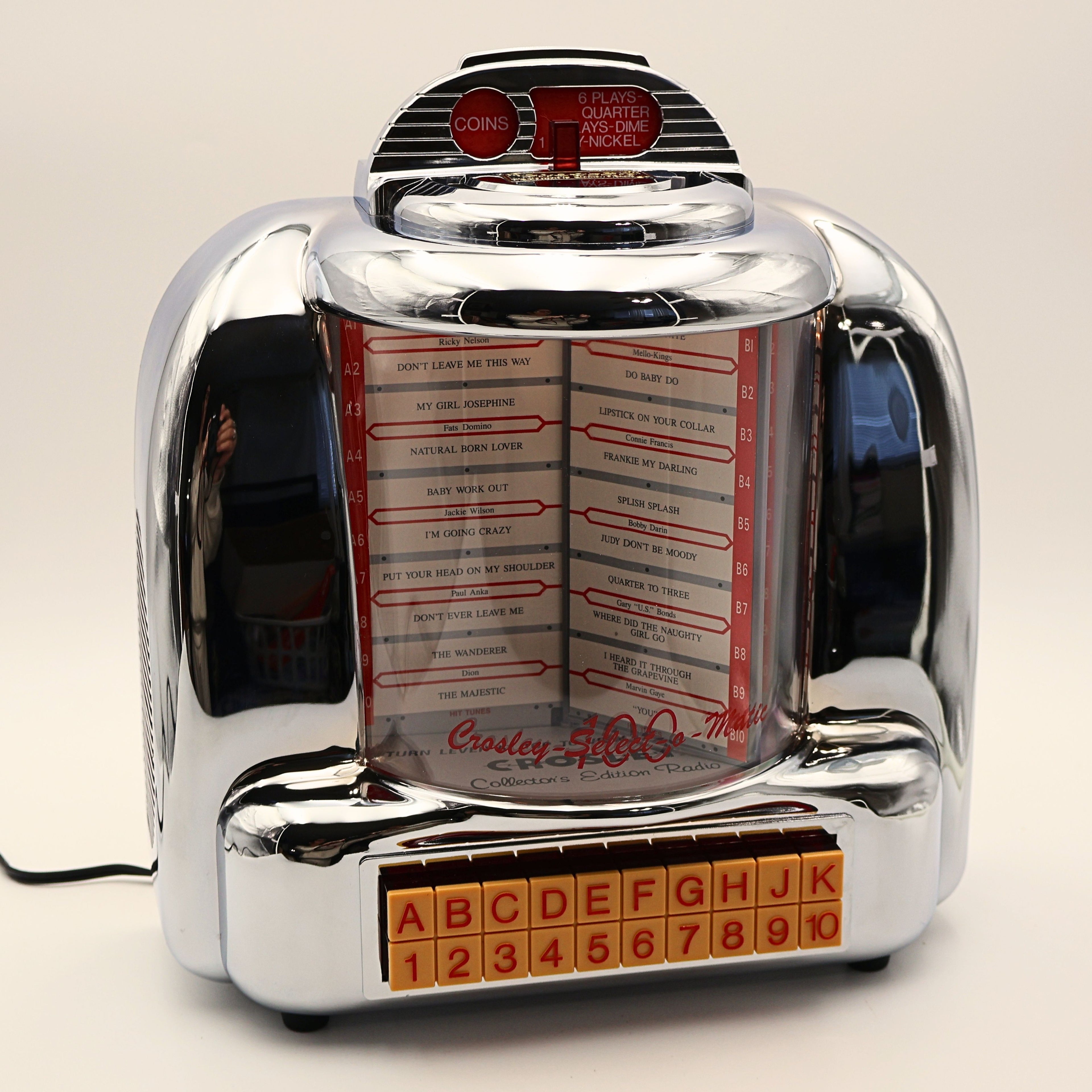 Vintage Crosley CR-9 jukebox radio with illuminated display and chrome finish, retro 1950s diner decor music player featuring rotating song list and nostalgic lighting
