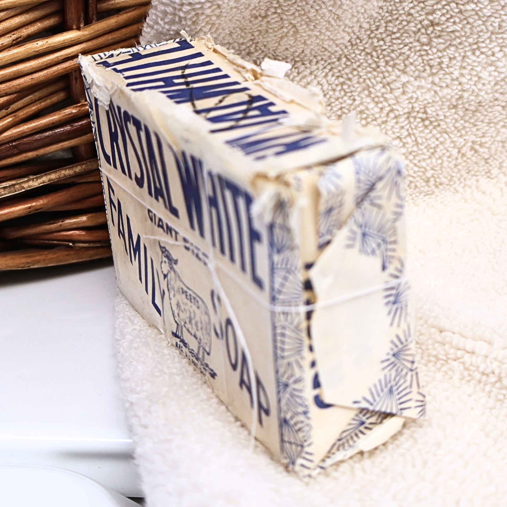 Side angle view of an original Crystal White Family Soap bar showing the vintage blue and white wrapper, folded packaging, and authentic age-related wear. Ideal for collectors of vintage advertising, farmhouse decor, laundry room displays, general store collections, and retro household memorabilia.