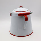 Rear view of large white enamel cowboy coffee pot with red handle and metal bail