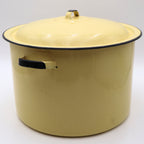 Side profile of a vintage yellow enamelware stock pot with matching lid featuring classic black trim, sturdy side handles, and a glossy buttery yellow finish. A timeless vintage farmhouse decor piece with authentic mid-century charm.