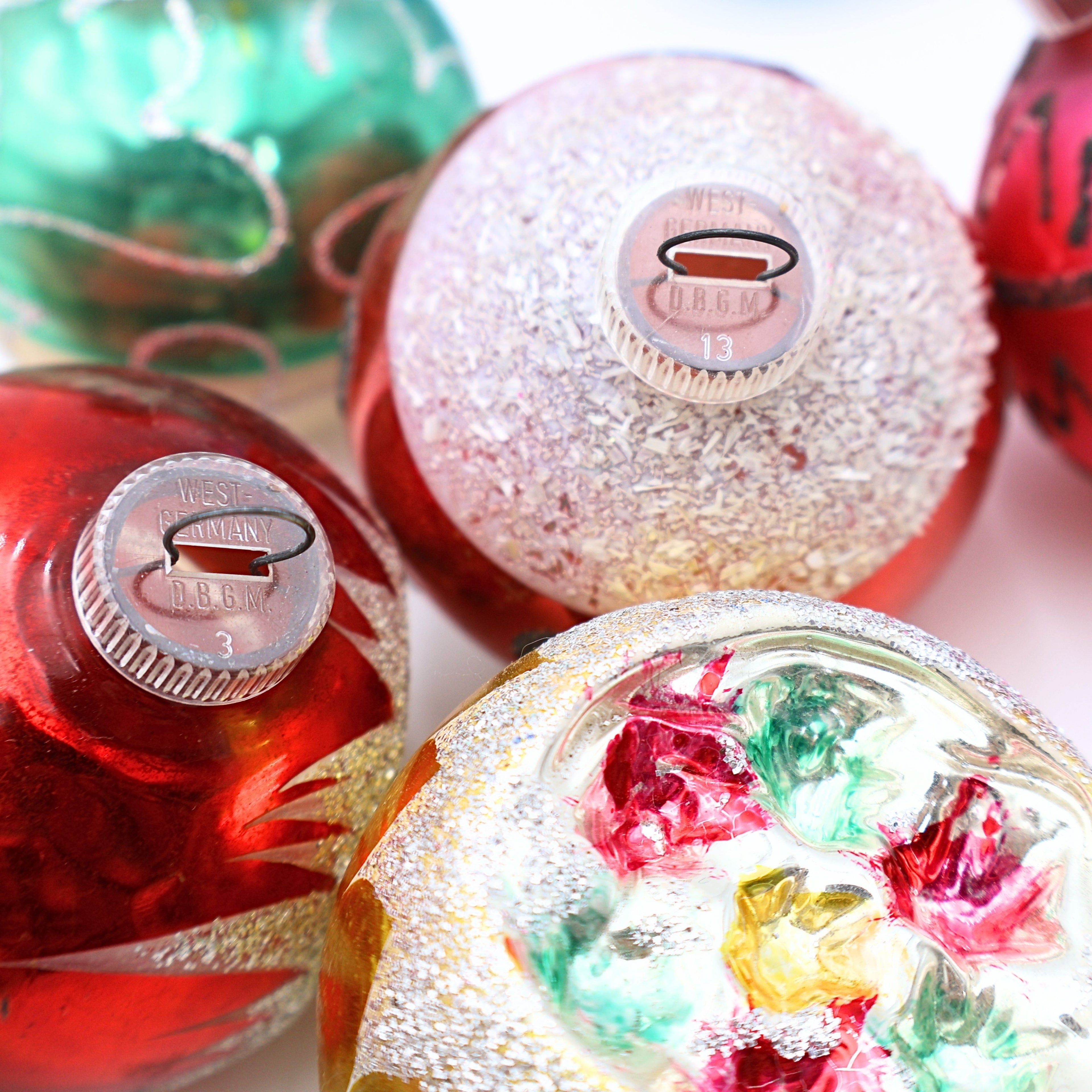 Closeup of vintage floral reflector Christmas ornaments with colorful jewel tone indents and silver mica glitter