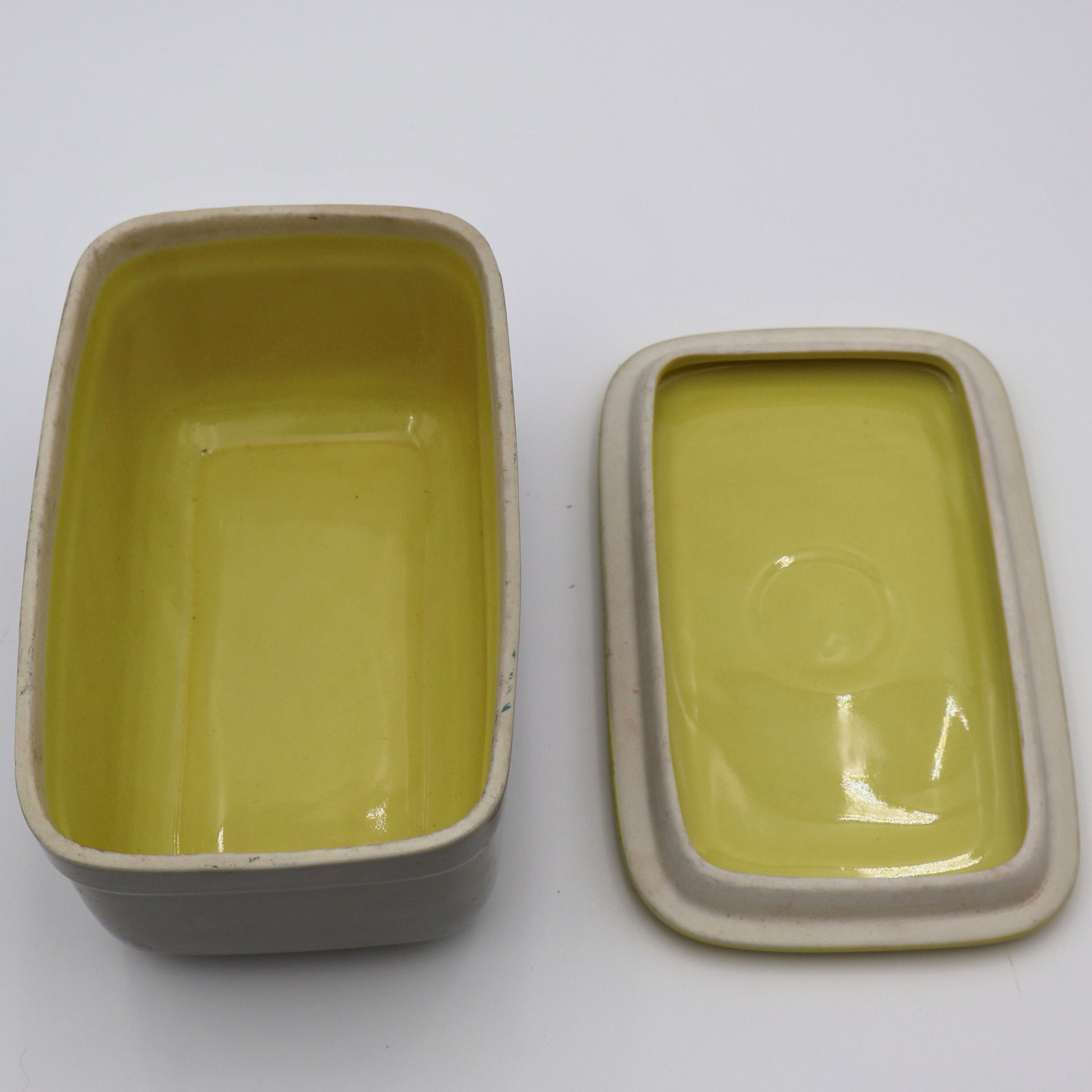 Open vintage GE refrigerator dish with lid showing ceramic storage capacity and mid century design.