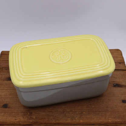 Top view of vintage General Electric refrigerator dish with yellow lid and gray ceramic body made by Hall China.