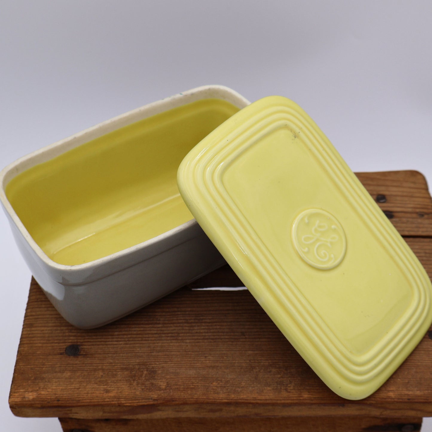 Close up of yellow lid on vintage GE refrigerator dish with glossy glaze and mid century design.