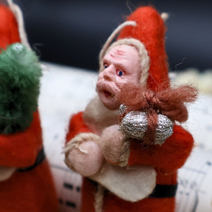 Side angle view of vintage German Belsnickle Santa ornaments highlighting dimensional handmade construction