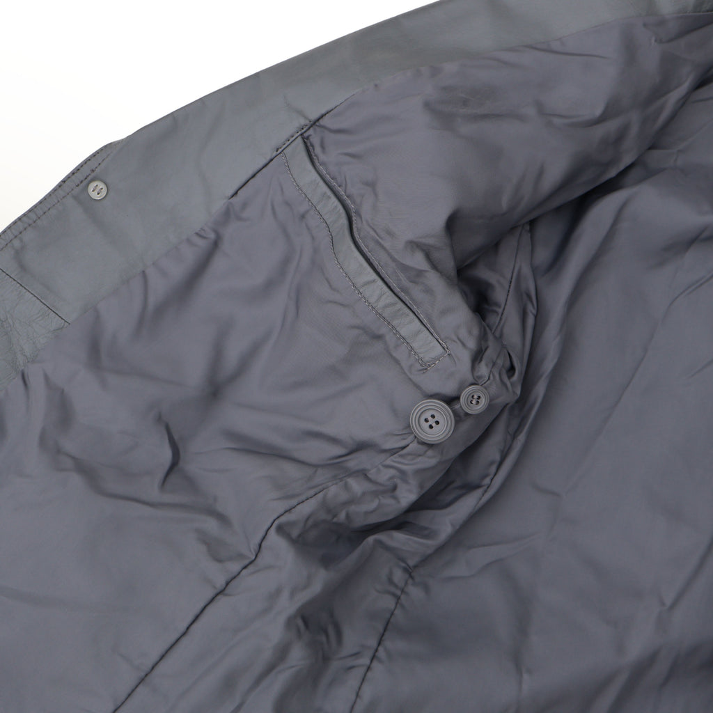 Close up of gray leather blazer front pocket with stitched leather trim and soft lining.