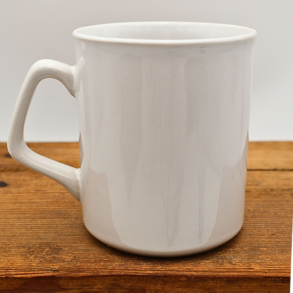Rear view of the vintage white ceramic Jamaica souvenir mug displaying the plain glazed back opposite the printed travel design. The clean back highlights the simple form commonly found on collectible vacation mugs from the late twentieth century.