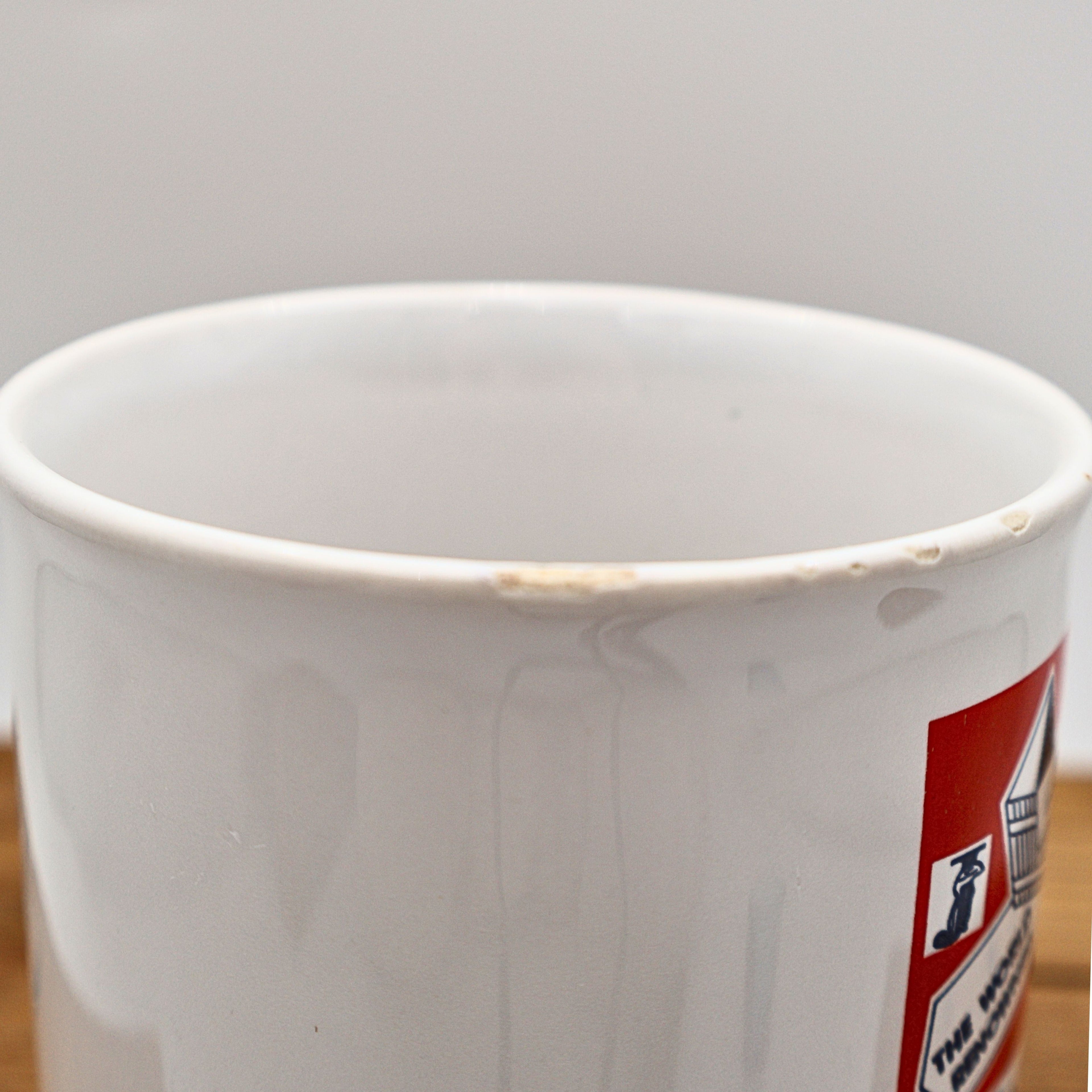 Close-up photograph of the upper rim of the vintage Jamaica souvenir mug documenting minor glaze wear and small areas of finish loss from age and previous use. This detailed condition image helps collectors evaluate the ceramic mug before purchase.