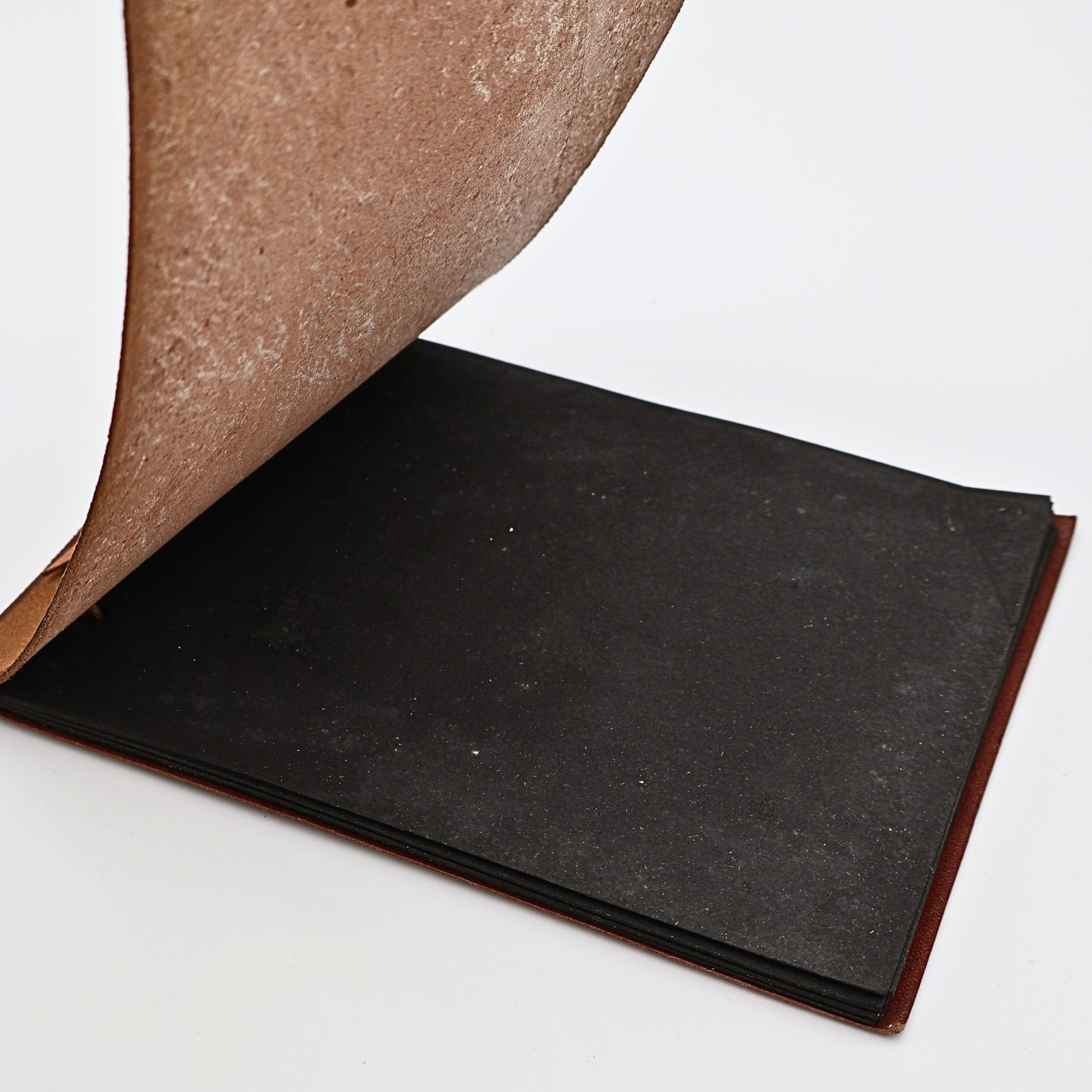 Open vintage leather photo album with black pages