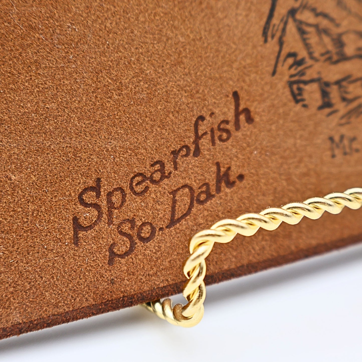 Close up of stamped artwork Spearfish So Dakota on vintage leather photo album