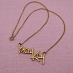 Full view of vintage Mary Kay Lady gold tone necklace with delicate chain and script pendant, classic direct sales jewelry.