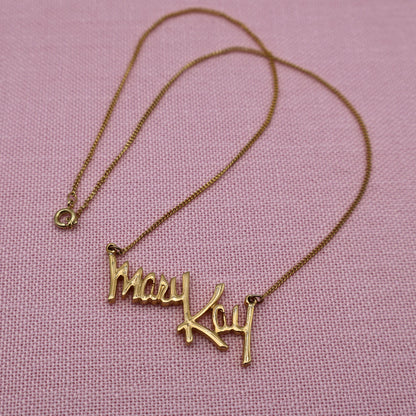 Full view of vintage Mary Kay Lady gold tone necklace with delicate chain and script pendant, classic direct sales jewelry.