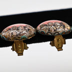 Side profile of vintage Mount Rushmore clip-on earrings displaying the clear domed tops, scalloped gold-tone metal settings, and functioning clip mechanisms. This perspective highlights the dimensional construction and layered scenic design typical of vintage Americana souvenir jewelry.