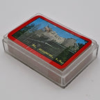 Angled view of the vintage Oker Mount Rushmore souvenir playing card deck resting on its clear plastic storage case. The unused deck remains factory sealed, showcasing the iconic South Dakota landmark artwork on the card backs and the compact travel souvenir presentation.
