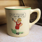 Vintage Ovaltine ceramic advertising mug featuring Harold Gray artwork of a young girl holding Ovaltine with a humorous speech bubble and green rim.