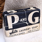 Authentic vintage P&G White Laundry Soap bar from the World War II era displayed in its original navy and white paper wrapper. This Procter & Gamble advertising collectible features the iconic P&G logo and is ideal for vintage laundry room decor, Americana collections, farmhouse displays, and advertising memorabilia enthusiasts.