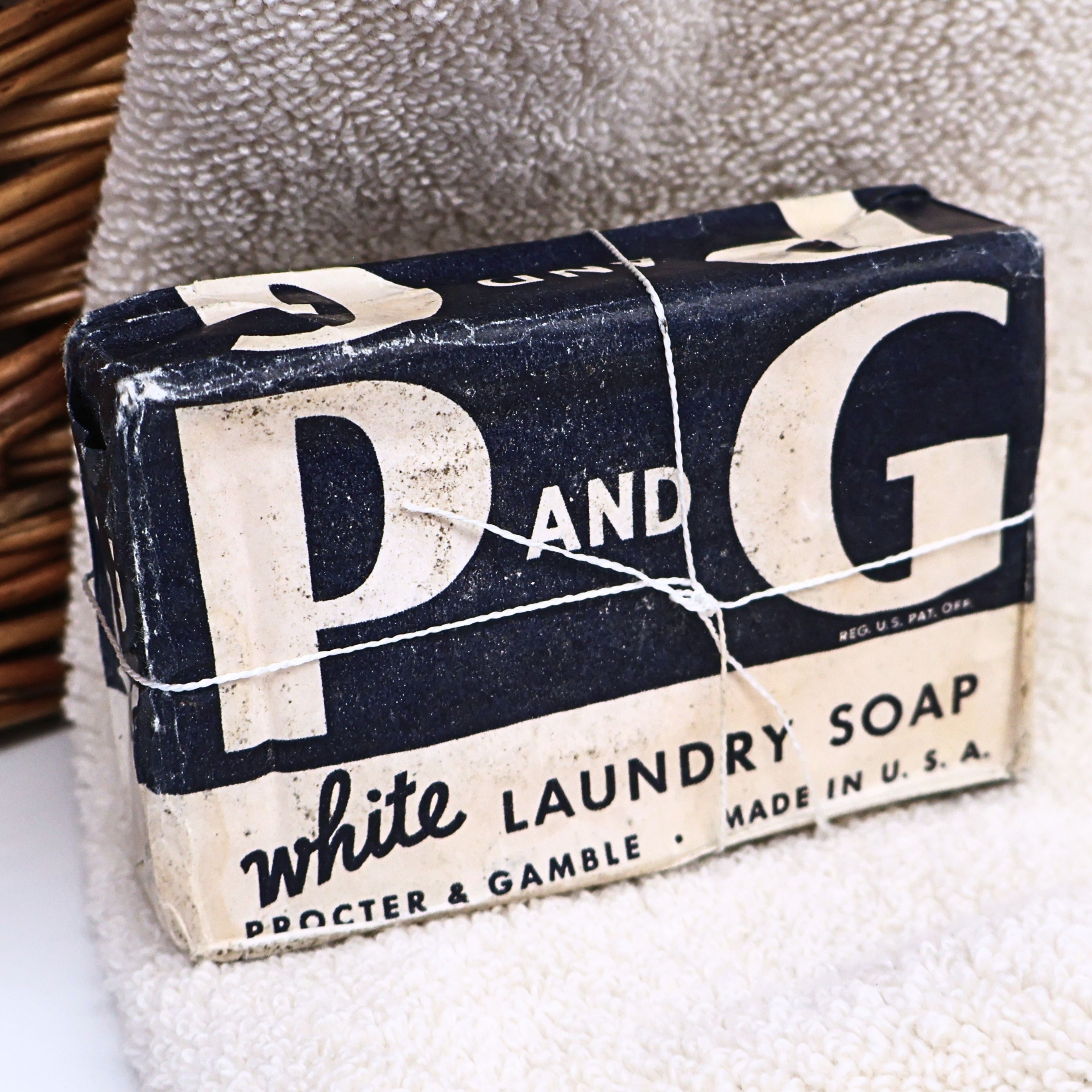 Authentic vintage P&G White Laundry Soap bar from the World War II era displayed in its original navy and white paper wrapper. This Procter & Gamble advertising collectible features the iconic P&G logo and is ideal for vintage laundry room decor, Americana collections, farmhouse displays, and advertising memorabilia enthusiasts.