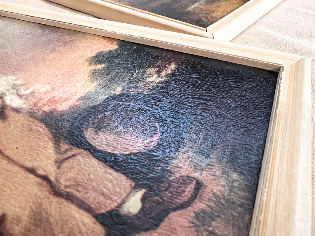Detail of the boy portrait’s lower-right area, showing a basket, dark landscape colors, and part of the child’s trousers and shoes. Strong angled reflections reveal the textured surface, while the adjoining cream frame shows small areas of finish wear.