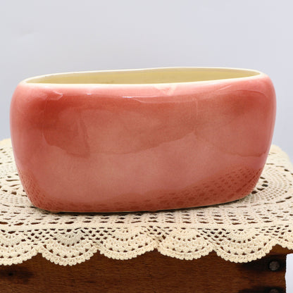 Back view of vintage Royal Copley planter showing glossy blush pink glaze and oval mid-century shape.