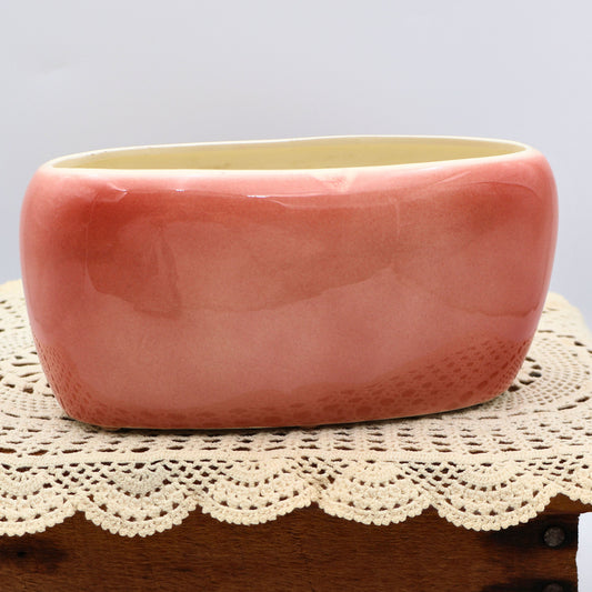 Back view of vintage Royal Copley planter showing glossy blush pink glaze and oval mid-century shape.