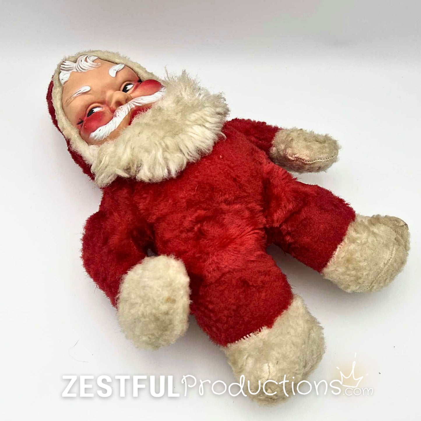 Full body view of vintage 1950s Santa Claus plush doll laying flat with red plush suit and white trim. Mid century modern Rushton style Christmas collectible for retro holiday decor and nostalgic seasonal displays.