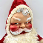 Close up of vintage 1950s Santa Claus plush doll face with molded features, rosy cheeks, white eyebrows, and detailed beard. Retro Rushton style Christmas collectible with nostalgic mid century holiday appeal.
