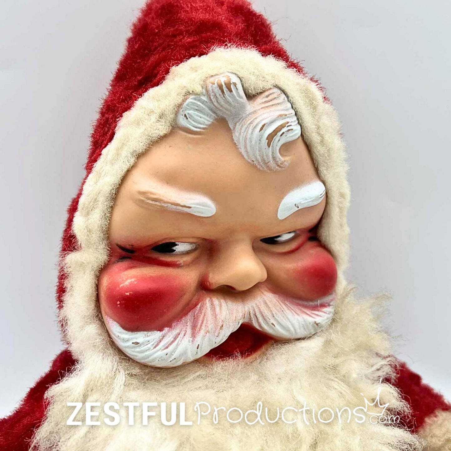 Close up of vintage 1950s Santa Claus plush doll face with molded features, rosy cheeks, white eyebrows, and detailed beard. Retro Rushton style Christmas collectible with nostalgic mid century holiday appeal.