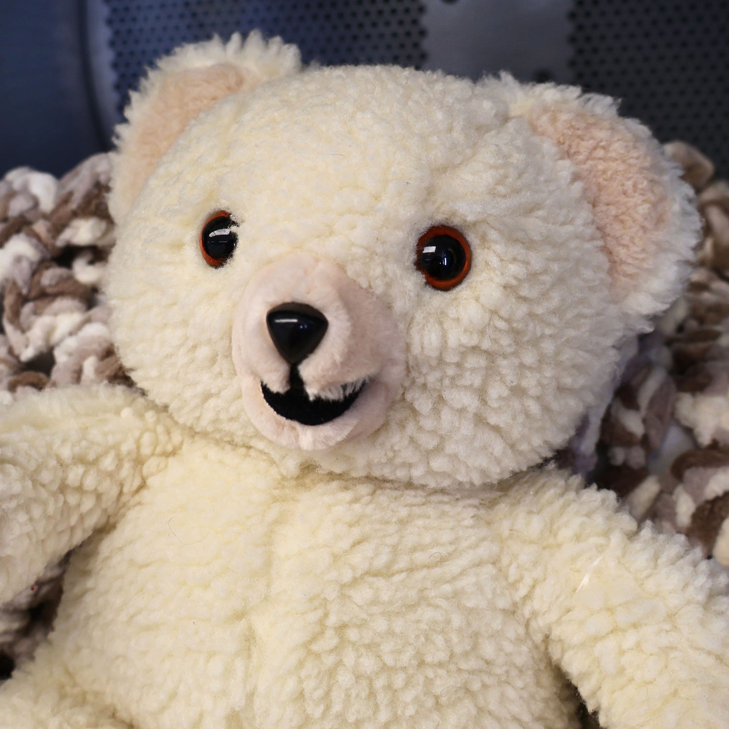 Close-up portrait of an original 1986 Lever Brothers Snuggle Bear featuring expressive brown safety eyes, soft ivory plush, and a classic smiling expression. Perfect for collectors of vintage advertising mascots, retro plush toys, and cozy nursery or shelf decor.