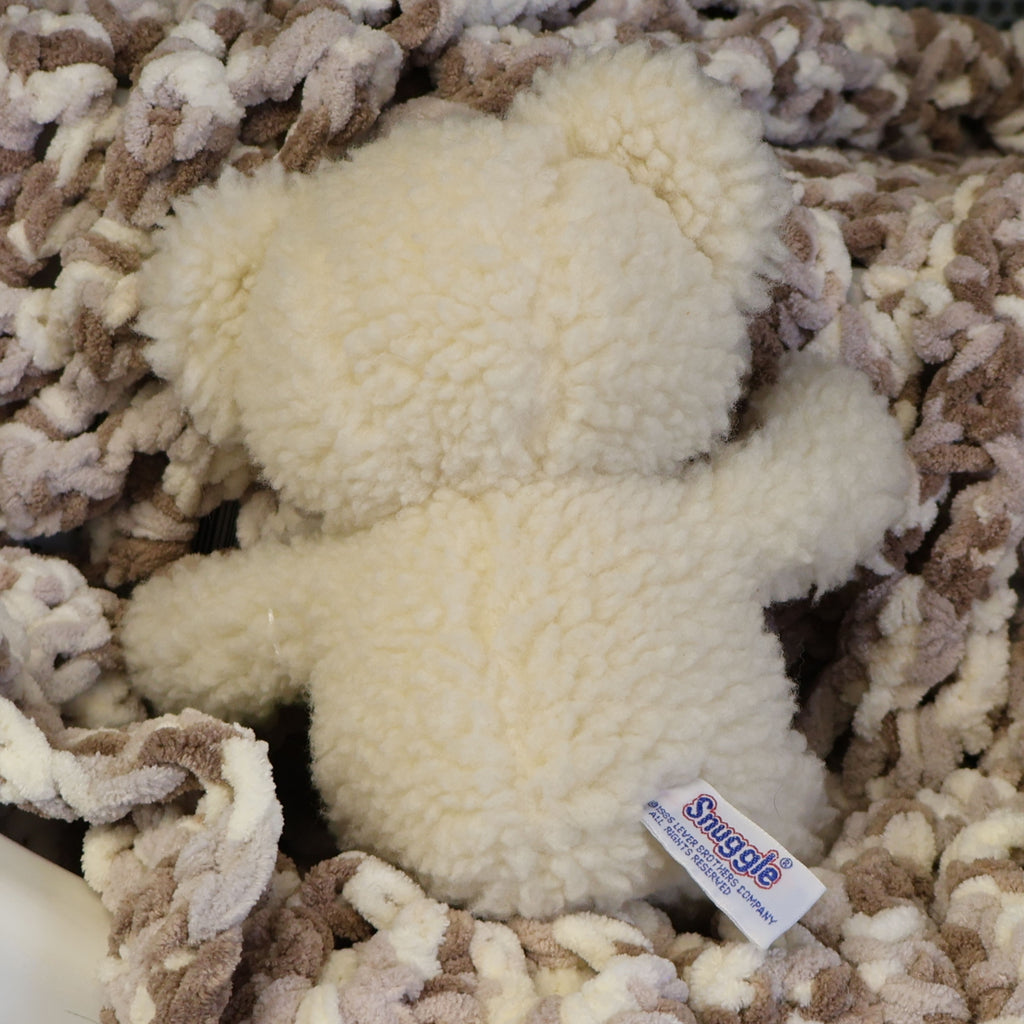 Rear view of a vintage Snuggle plush displaying its original sewn-in Lever Brothers copyright tag and fluffy cream plush. This authentic 1986 advertising mascot is a wonderful addition to nostalgic collections, laundry room decor, or vintage displays.