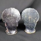 Rear view of two vintage Gurley figural turkey candles against black fabric. Their broad, flattened tail backs and rounded pedestal bases are coated in dark brown and black wax, with numerous scratches, rubbed areas, embedded lint and other visible signs of age and handling.