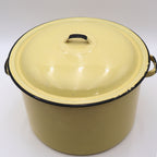 Angled front view of a vintage yellow enamelware stock pot with matching lid showcasing its classic farmhouse silhouette, black trim, and warm buttery yellow finish. A timeless piece for cottagecore décor, vintage kitchen collections, and rustic home styling.